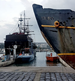 Ship moored at harbor against sky