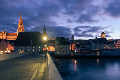 Illuminated buildings against sky at dusk