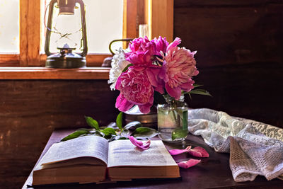 Still life of vintage items and a bouquet of peonies on a table by the window in an  village house