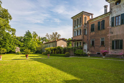 Lawn by building against sky