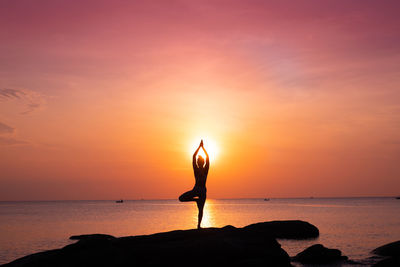 Man looking at sea against sky during sunset