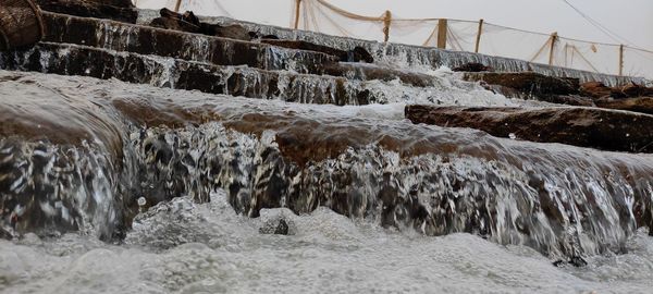 Panoramic shot of icicles on rocks against sky during winter