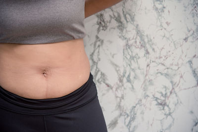 Close-up of woman standing against wall