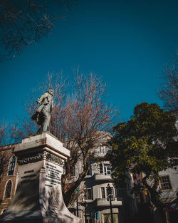 Low angle view of statue in city against clear sky