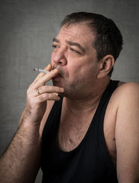 Man smoking against wall