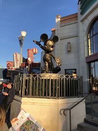 Statue in city against sky