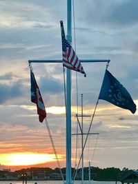 Low angle view of flag against sky at sunset