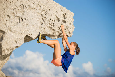 Low angle view of woman against blue sky