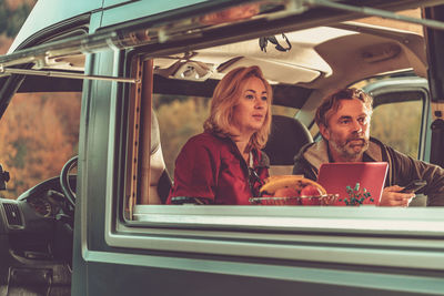 Couple watching tv while sitting at motor home