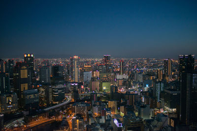 Illuminated cityscape against sky at night