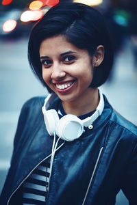 Portrait of smiling young woman standing on street