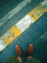 Low section of man standing on footpath