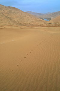 1055 unidentified lake mirrors a megadune of the badain jaran-gobi desert. inner mongolia-china.