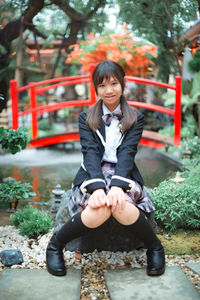Portrait of smiling girl sitting on tree