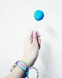 Close-up of hand holding multi colored balloons