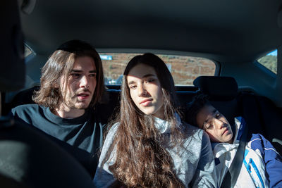 Portrait of siblings sitting in car