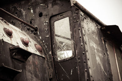 Close-up of abandoned airplane against sky