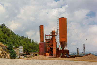 Smoke stack on field against sky