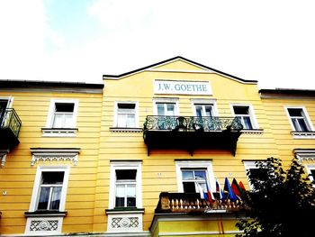 Low angle view of yellow building against sky