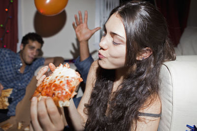 Young woman eating pizza