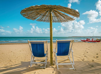 Scenic view of beach chairs on sandy beach