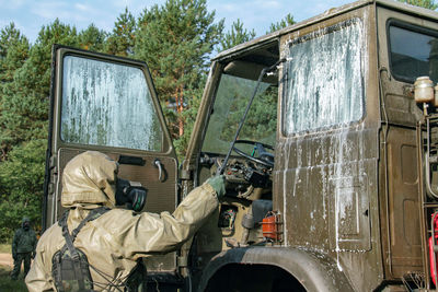 Male army soldier disinfecting truck