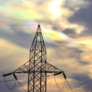 Low angle view of silhouette electricity pylon against sky