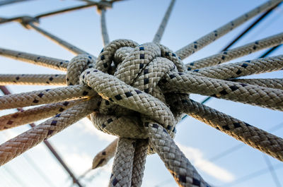 Low angle view of rope tied to bollard