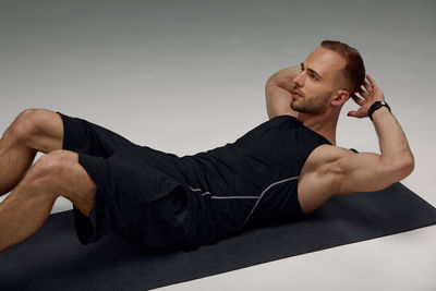 Low angle view of man sitting on sofa at home