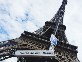 Low angle view of communications tower against cloudy sky