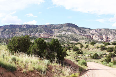 View of dirt road along rocky mountains