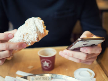 Midsection of man having breakfast at table