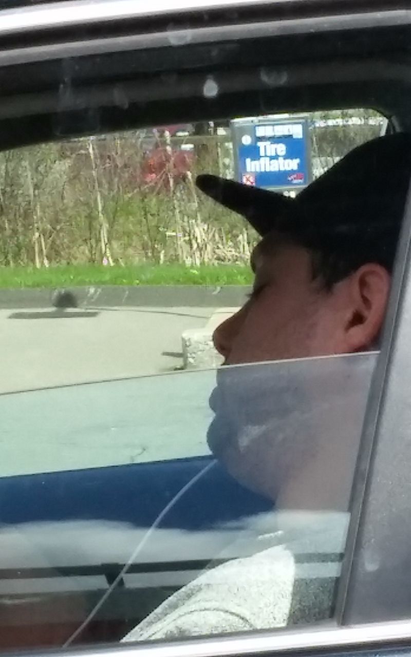 CLOSE-UP OF MAN LOOKING THROUGH WINDOW IN CAR