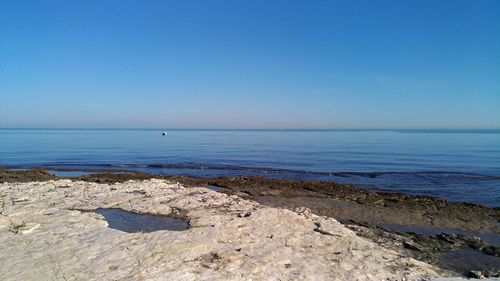 Scenic view of sea against clear blue sky