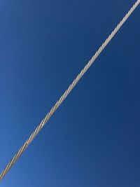 Close-up of a electric wire against clear blue sky