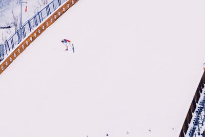 Low angle view of people skiing on snow against sky