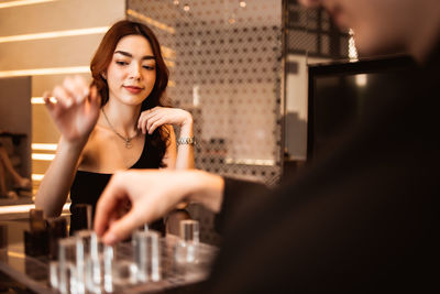 Man and woman playing board game on table