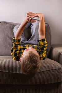 Rear view of man sitting on sofa at home