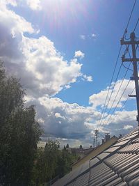 Power lines against cloudy sky