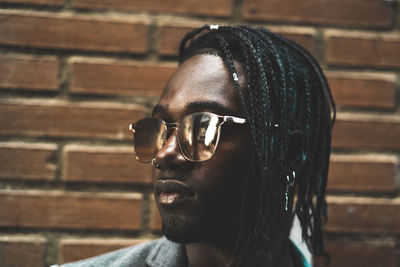 Close-up portrait of young man against wall