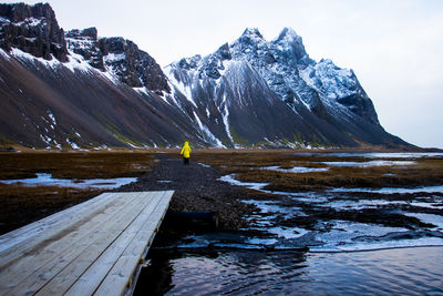 Rear view of man on snowcapped mountain against sky