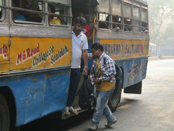 Full length of boy standing on bus