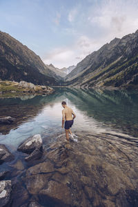 Man in lake against mountains