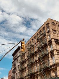 Low angle view of buildings against cloudy sky