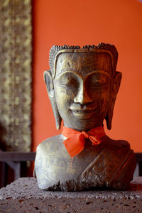 Close-up of buddha statue against wall