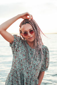 Portrait of smiling young woman against lake