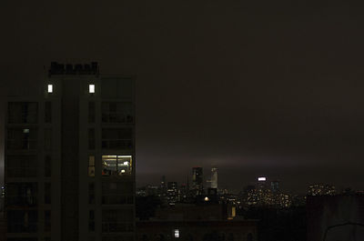 Illuminated cityscape against sky at night