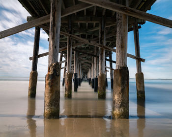 Wooden pier on sea against sky