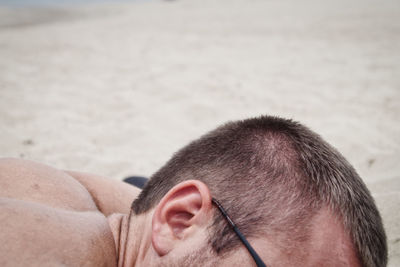 Close-up of man lying at beach