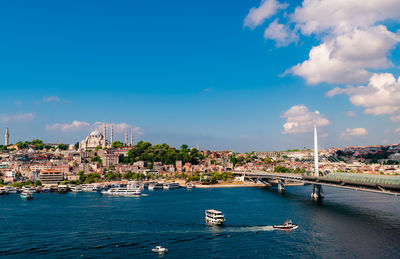 Sailboats in sea against buildings in city